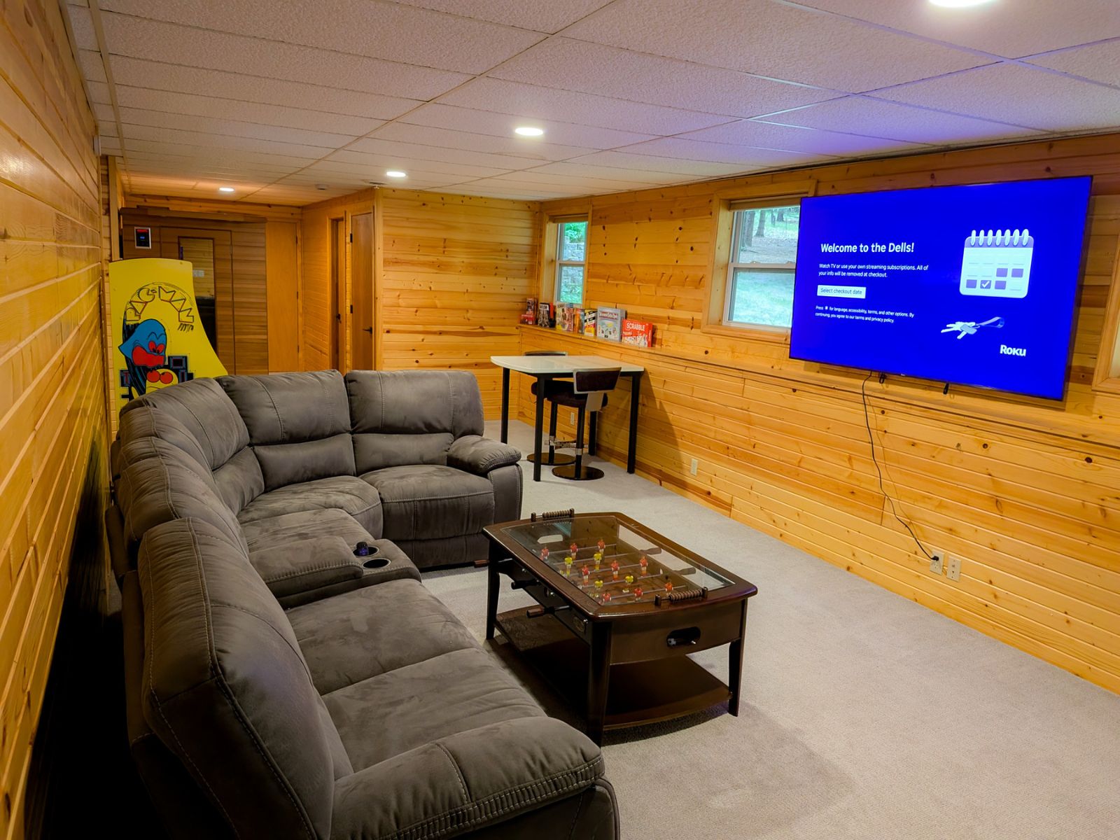 Game room, wide angle showing the seating, television, foosball table, and arcade game